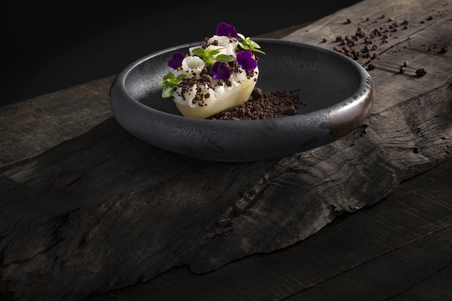 Gourmet-Gericht auf Altholz, stimmungsvoll inszeniert – Foodfotografie für gehobene Gastronomie-Konzepte.
