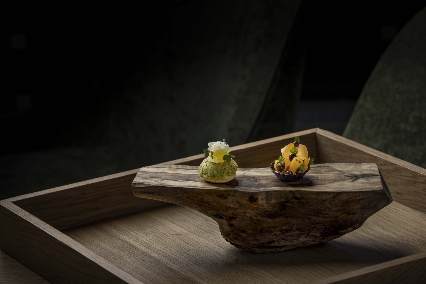 Kleine Köstlichkeiten auf Naturmaterialien – kunstvolle Food-Präsentation mit Textur-Kontrasten.