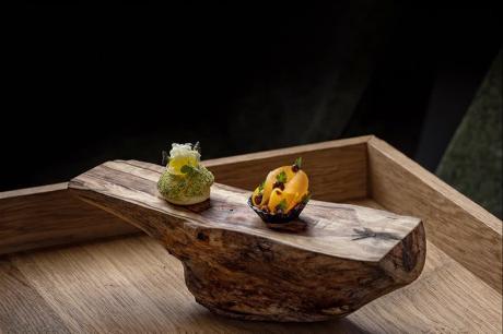 Amuse-Bouche auf rustikalem Holzbrett, Sterneküche in Szene gesetzt
