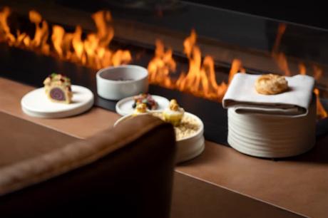 Gedeckte Teller vor offener Feuerstelle – stimmungsvolle Gastronomie-Fotografie