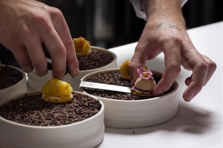 Koch richtet ein Dessert von Hand an – Detailaufnahme aus der Küche