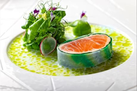 Lachs mit Kresse und grünem Kräuterfond auf weißem Teller