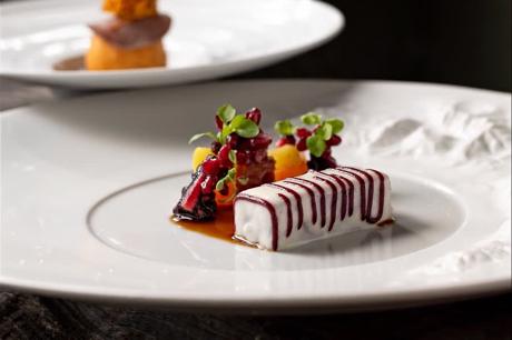 Dessert mit gestreifter Terrine und Fruchtgel auf weißem Teller