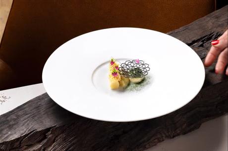 Dessert mit filigranem Zuckergitter auf weißem Teller